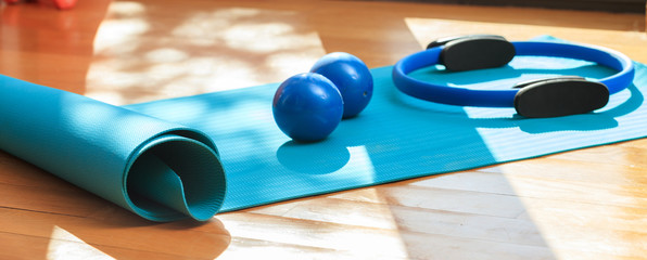 Yoga mat and exercise weights on wooden floor - obrazy, fototapety, plakaty