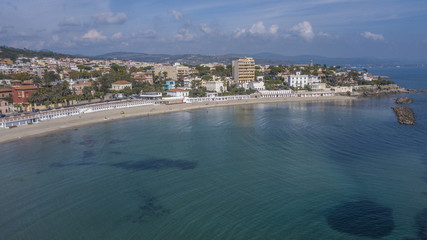 Fototapeta na wymiar Vista aerea della costa presso il comune di Santa Marinella, vicino Roma, in Italia. In spiaggia non ci sono ombrelloni e poche persone fanno il bagno in mare.