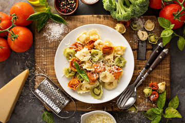 Red, white and green tortellini with vegetables and cheese - obrazy, fototapety, plakaty
