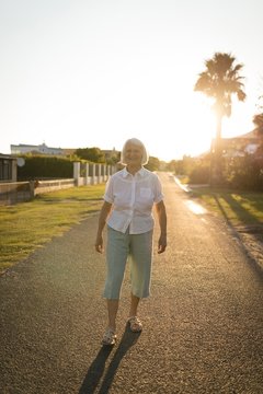 Senior Woman Walking On The Road