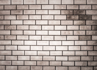 Brick wall with gray stain, light in the middle for background or wallpaper.