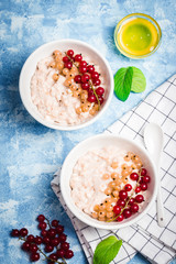 Banana berry oatmeal porridge with blue background. Healthy breakfast. Top view, space for text. 