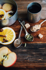 Mulled wine hot drink with citrus, apple and spices in aluminum casserole and Fir branch on concrete background