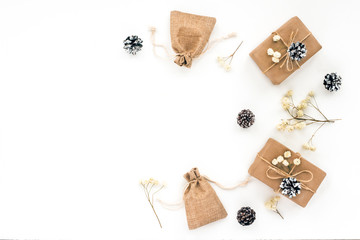Christmas gift, branches, white christmas decoration, white pine cone on white background. Top view, flat lay