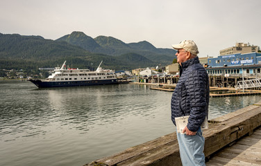 Fototapeta premium JUNEAU, ALASKA- SEPT 3, 2017: Juneau Pier where it is busy with with sea planes and big cruise ships. Juneau is the capital of Alaska.