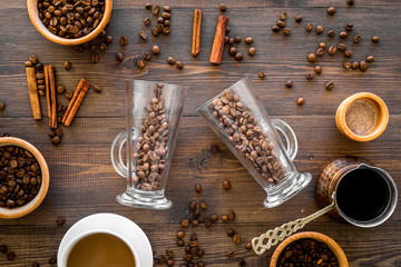 Make coffee in turkish coffee pot. Coffee beans, cinnamon on wooden background top view