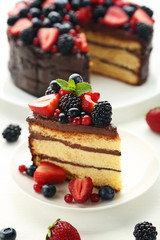 Piece of chocolate cake with berries in plate on wooden table