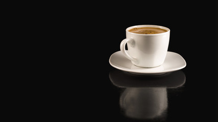 Coffee in the white cup on the black background