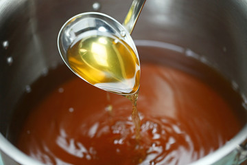 making chicken consomme soup in a pot