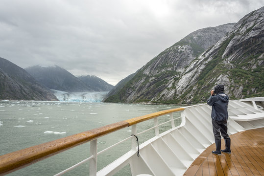 Cruise ship visitor taking photo of a big glacier in Glacier bay national park, Alaska