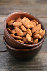 Almonds in bowl on wooden table