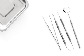 Set of dentists tools near cuvette on white background  top view copyspace