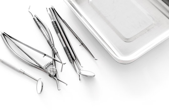 Set of dentists tools near cuvette on white background  copyspace