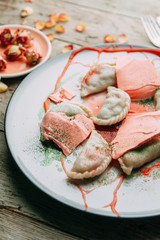 dumplings with potatoes, cheese, berries, compositions for the menu of the restaurant, decorated with greens and sauce