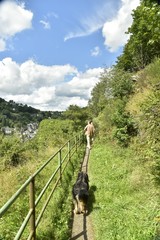 Promeneur avec son chien sur le passage étroit à flanc de colline en pleine nature longeant la...