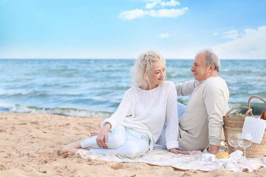 Happy Senior Couple Having Picnic On Sea Beach