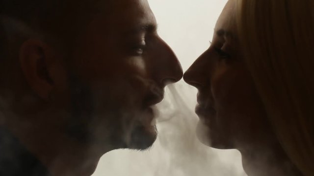 Man gives smoke kiss to woman. Vape culture