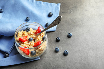 Tasty quinoa with berries in jar on table