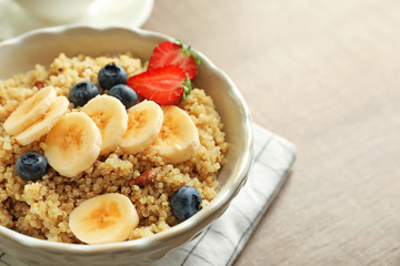 Plate with tasty quinoa on wooden table
