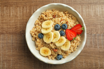 Plate with tasty quinoa on wooden table