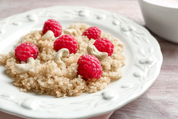 Plate with tasty quinoa on table, closeup