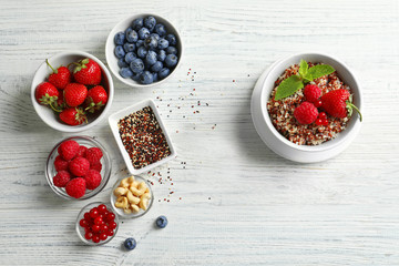 Beautiful composition with tasty quinoa on wooden table