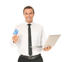 Young businessman holding credit card while using laptop on white background