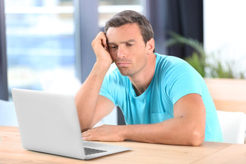 Young man using laptop at home