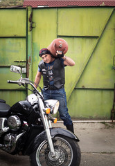 Fototapeta na wymiar Biker with a gas cylinder in the yard of his house.