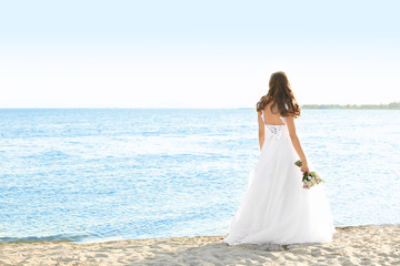 Fototapeta na wymiar Happy young bride on sea beach