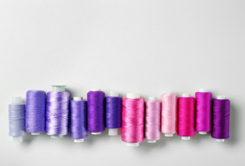 Violet and pink threads of different shades on white background
