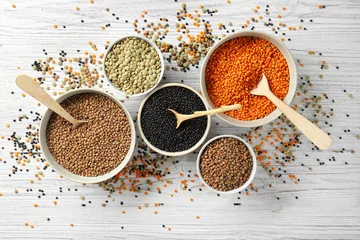 Foto op Canvas Bowls with different types of lentils on wooden table © Africa Studio