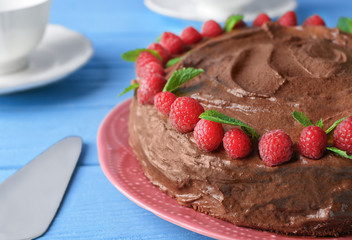 Plate with delicious chocolate cake on wooden background