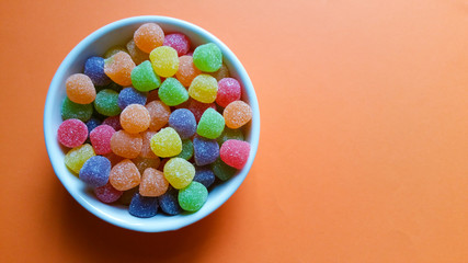 colored jelly beans on orange background