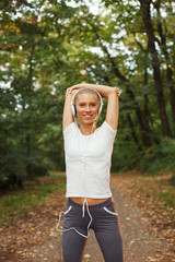 Young fitness woman runner stretching arms before run