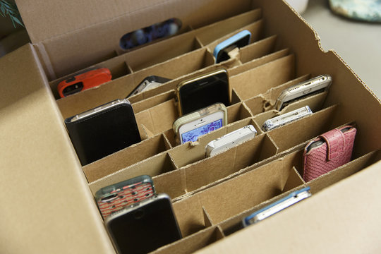 Smartphones owned by school kids in a box, stored by the teacher during class in a high school in the Netherlands in 2017.