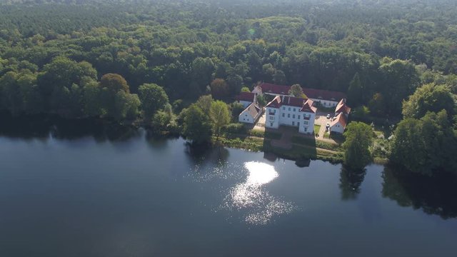 Drone view over blue lake Havel with sun reflection, aerial from famous castel in Grunewald and pan to Berlin skyline, Germany 4K birds eye view