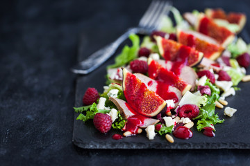 Delicious salad with fresh figs, duck meat and raspberry sauce
