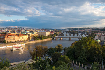 Fototapeta na wymiar View of the city of Prague and bridges over the river Vltava in the evening. The city is lit by the setting sun