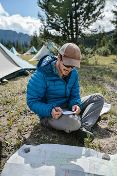 Young adventurer planning direction of travel with map and compass