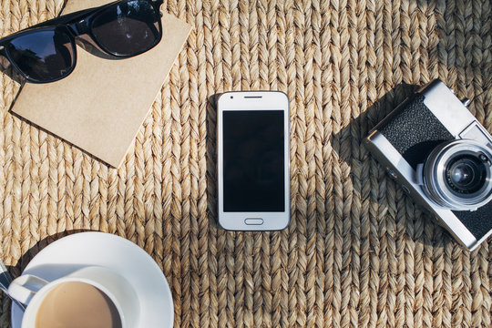 Blank mobile phone in the middle with travellers belongings.
