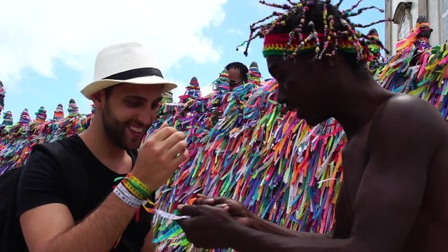 Brazilian Man Welcoming the Tourist giving some "Brazilian Wish Ribbons" in Salvador, Brazil - the ribbons are considered good luck charms