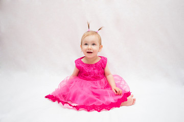 beautiful baby girl in pink dress with pigtails on head on white isolated background