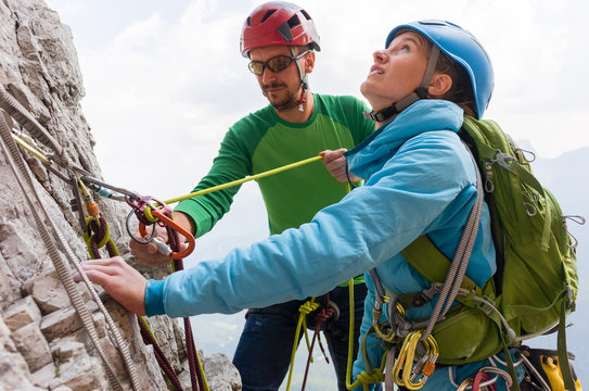Rock climbers on the cliff regroup and check their climbing equipment