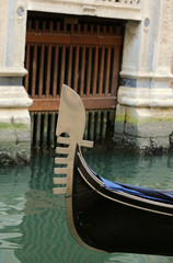 Fototapeta na wymiar bow of the gondola with the famous metal symbol in venice during