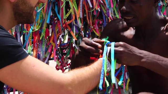 Brazilian Man Welcoming the Tourist giving some "Brazilian Wish Ribbons" in Salvador, Brazil - the ribbons are considered good luck charms