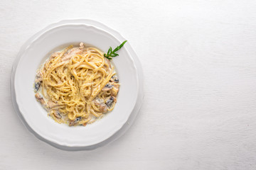 Pasta with chicken and mushrooms. Italian cuisine. On a wooden background. Top view. Free space for text.