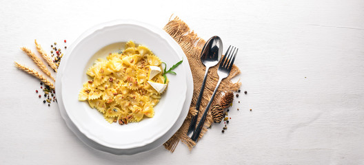 Pasta four cheeses. Italian food. On a wooden background. Top view. Free space for text.