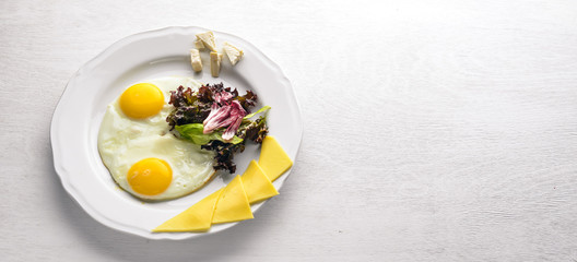 Scrambled eggs with cheese and herbs. On a wooden background. Top view. Free space for text.