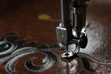Multilayer embroidery on brown leatherette with embroidery machine - close up with needle down -...